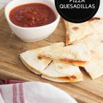 image created for pinterest of pizza quesadillas on a wooden chopping board with dipping sauce text in a black circle in upper right corner reads Pepperoni Pizza Quesadillas