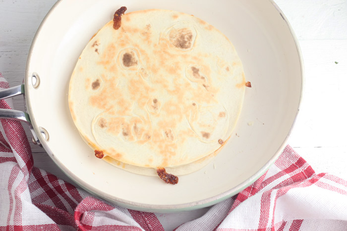 quesadilla cooking in a pan