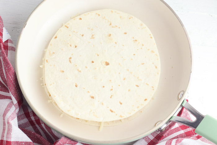 flour tortilla quesadilla in a pan ready to cook