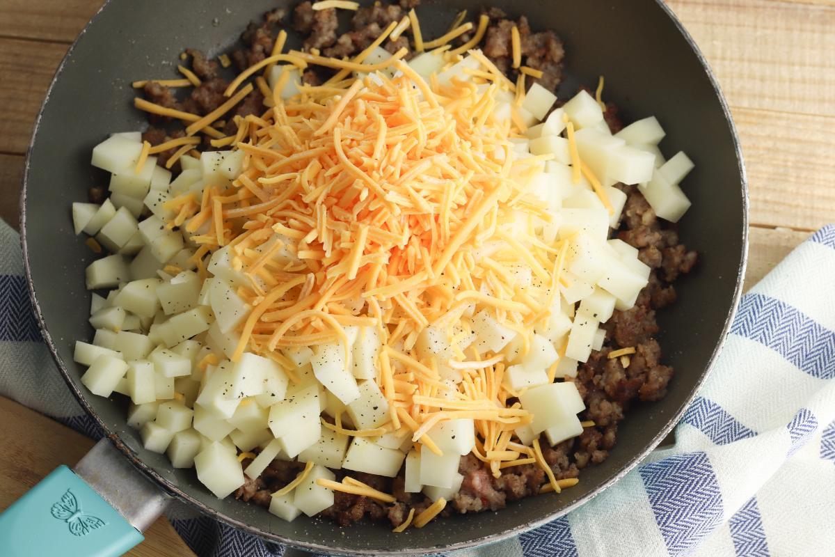 mixing cheese and potatoes with the browned italian sausage in a skillet.