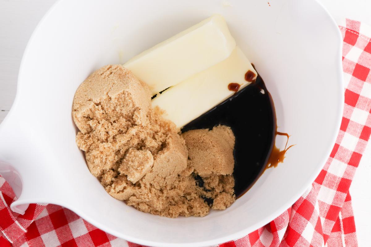 step 1 in making gingerbread men cookies, the sugars, butter and molasses in a bowl.